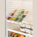 Kitchen food storage container being lifted from fridge shelf with organised compartments