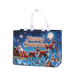 Blue Christmas tote bag with white handles featuring Santa Claus riding a sleigh with reindeer over a snowy Christmas village under a starry night sky