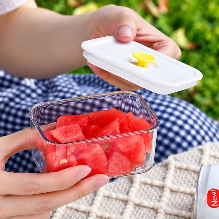 Clear food storage container with white lid and yellow centre seal holding watermelon